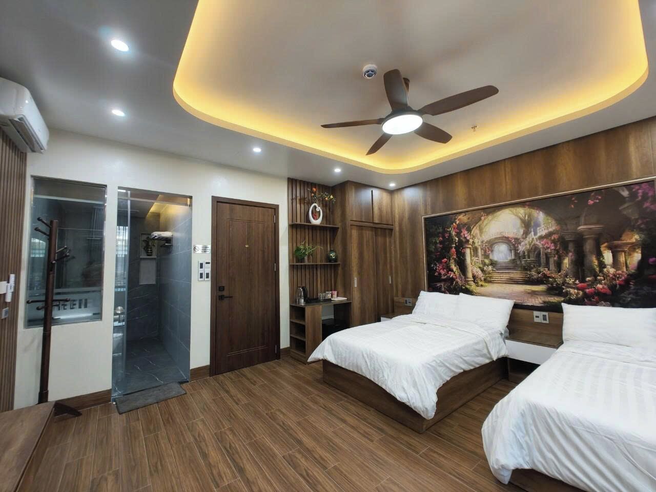 A bedroom with two beds, a ceiling fan, recessed lighting, a shower, and a mural on the wall.
