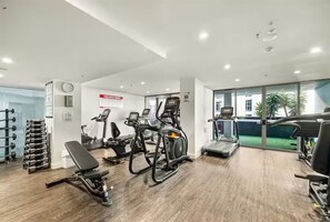 A modern gym with cardio machines, weight racks, and a bench. - River & fireworks visible from the balcony! (Brisbane)