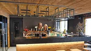 A bar area with a wooden ceiling, bar stools, and a counter with taps. - Beautiful apartment for 6 people with WIFI, terrace and pets allowed (Zinal)