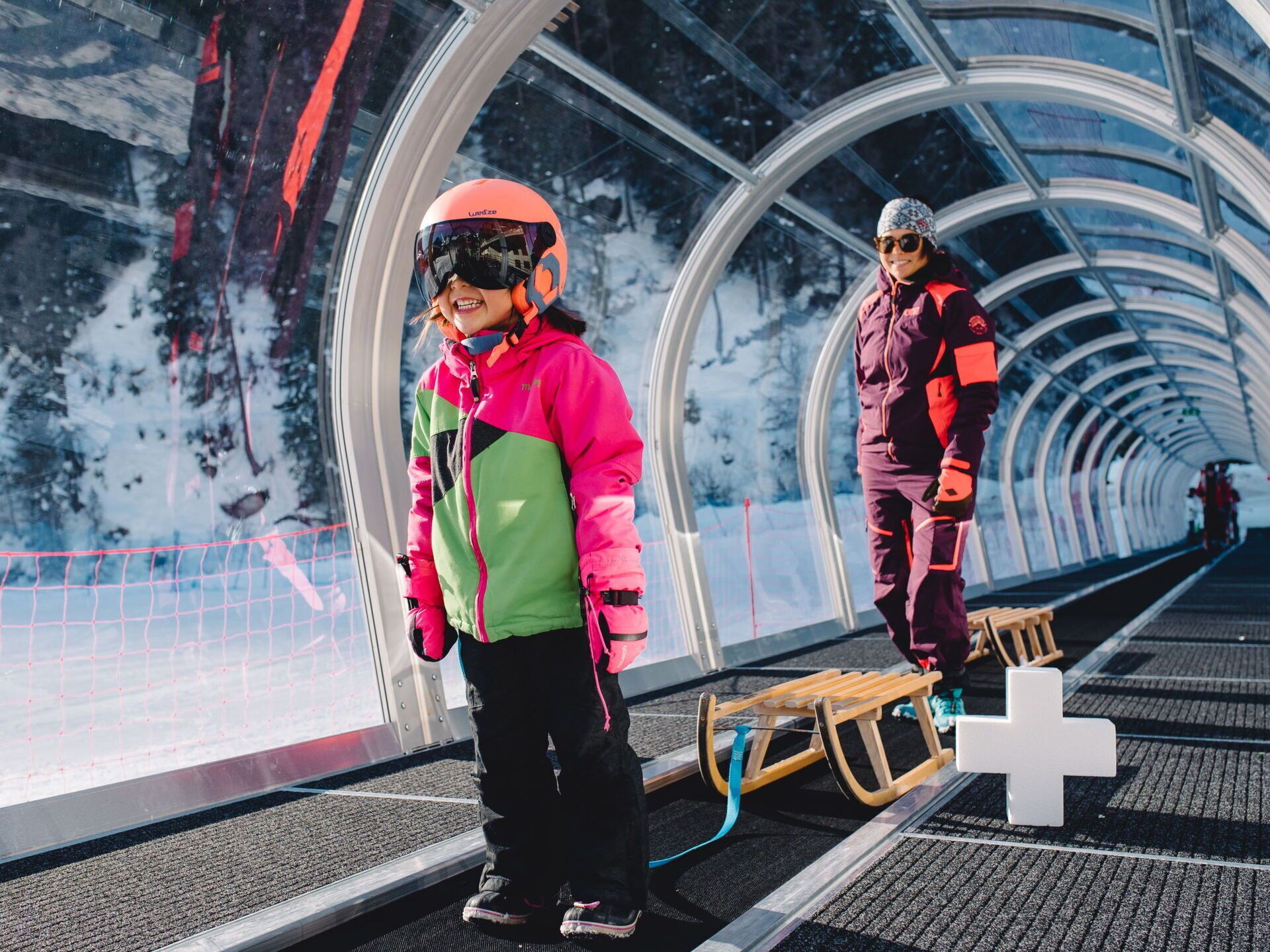 A snow-covered landscape with a transparent tunnel structure.