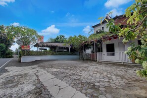 A courtyard with a thatched-roof structure, a white building with a balcony, and a sign reading 'ADA KAMAR'. - Hotel O near Parangtritis Beach formerly (Parangtritis)