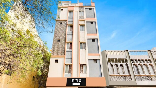 Un hotel con fachada moderna, un letrero y plantas en macetas en la entrada.