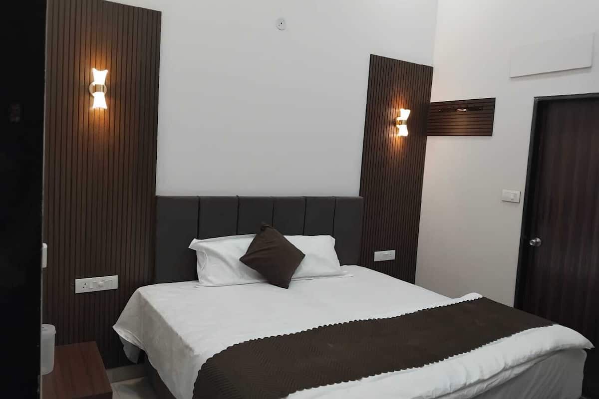 Ein Hotelzimmer mit einem Bett, einer Wandpaneele aus Holz und zwei Wandleuchten.