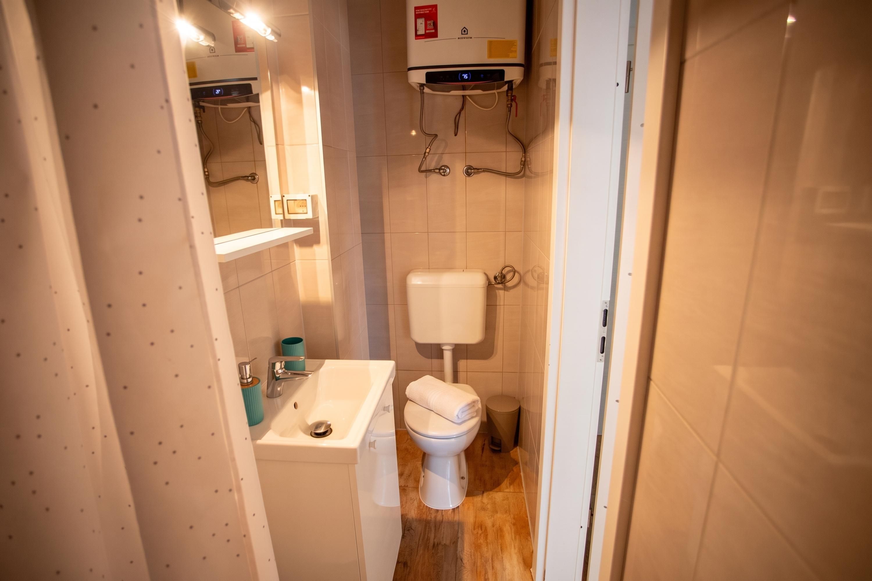 A bathroom with a toilet, sink, and a water heater.