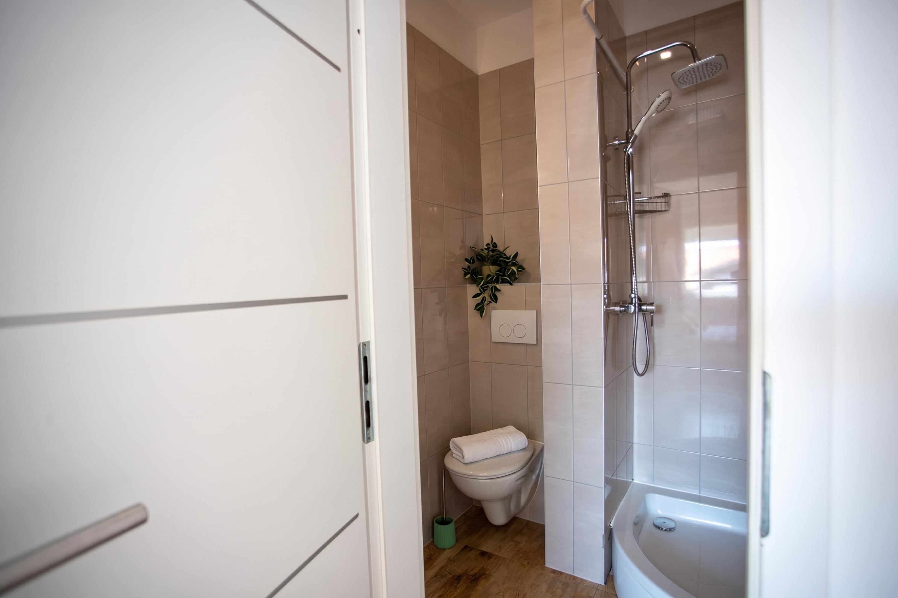 Un bagno con il water, una doccia e una vasca da bagno.