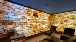 A spa room with a mosaic wall, a reception desk, and two reclining chairs. - 307a, Diamond Two Bedroom Apartment (Vlorë)