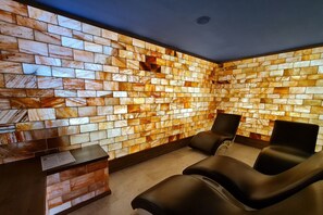 Ein Spa-Bereich mit Wand aus Mosaiken, einer Rezeption und zwei Liegesesseln.