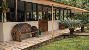 A building with large windows, a wooden bench, and a palm tree. - Ilan Ilan tortuguero (Colorado)