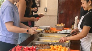 A buffet setup with various food items, plates, and a serving counter. - Ilan Ilan tortuguero (Colorado)