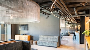 Un espacio de oficina moderno con sofá, comedor y cocina.