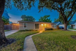 A single-story house with a front yard, a pathway leading to the entrance, and a tree on the right. - Your Houston home base near the Medical Center, NRG, Downtown, and top attractions. (Houston)