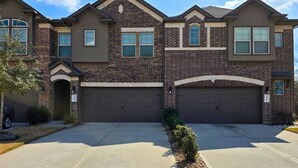 A two-story residential house with a brick facade, two garage doors, and a driveway. - Corporate Retreat Near Houston and Med Ctr (Pearland)