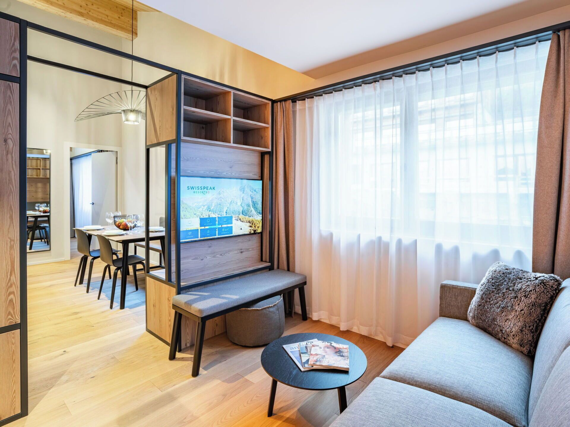 A modern living room with a TV, sofa, and dining area.