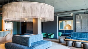 A modern lounge area with a large woven light fixture, blue seating, and a wooden bench. - Beautiful apartment for 4 people with WIFI, TV, terrace and pets allowed (Les Collons)