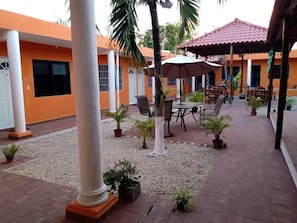 An outdoor patio area with seating, potted plants, and a tiled floor. - Hotel hospedaje el Rincon Bacalar  (Bacalar)