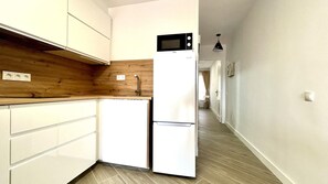 A compact kitchen with white cabinets, a wooden countertop, a built-in microwave, and a sink. - Welooveyou Atlantico your place to discover the island (Costa Calma (incl. Urbanización Cañada del Río))