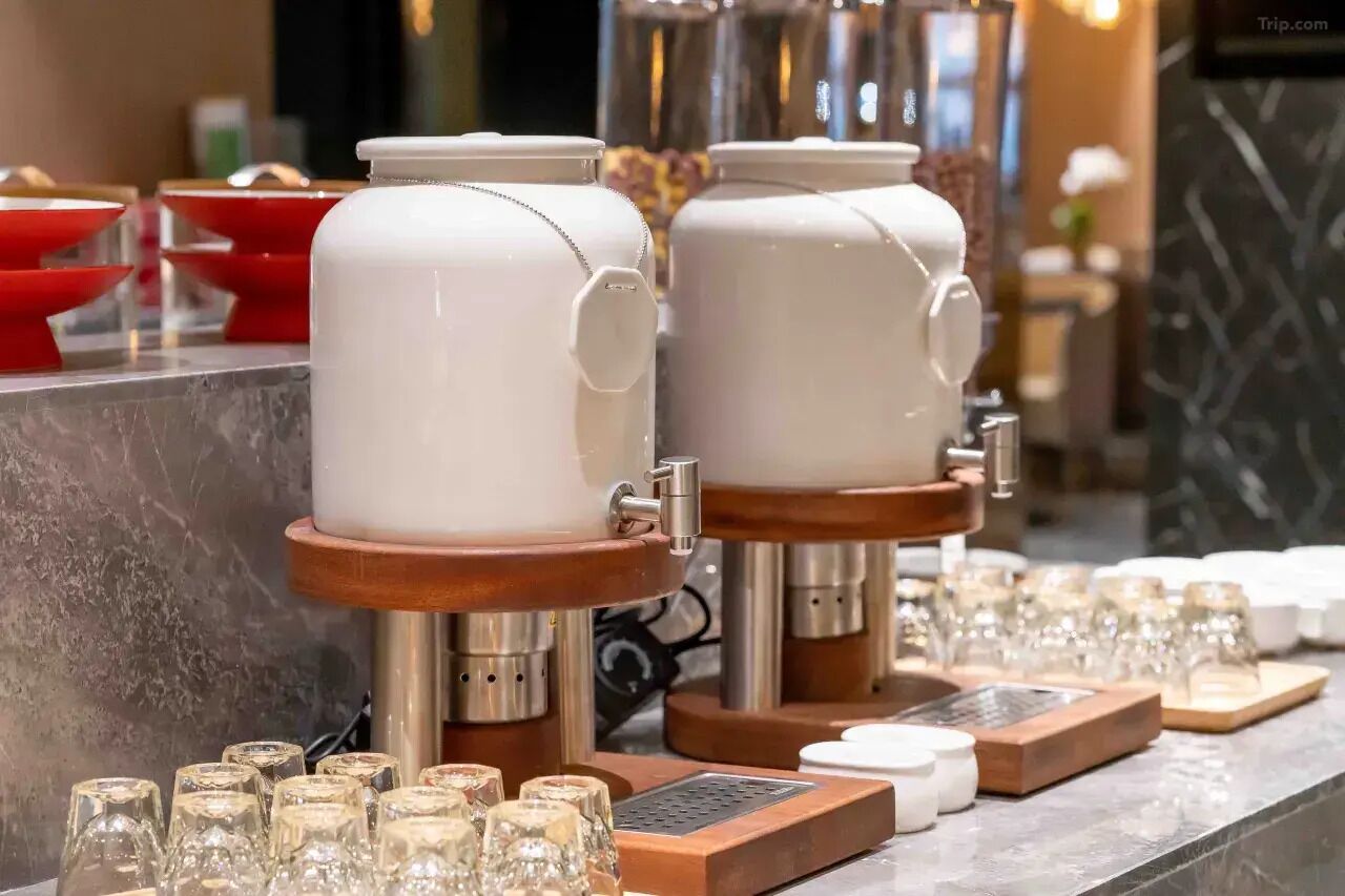 Two coffee machines with dispensers, a marble countertop, and several glass cups and saucers.