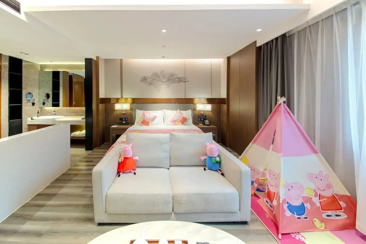 Une chambre d’hôtel avec un lit, un canapé, une petite table, une tente et une salle de bain.