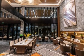 A modern interior with a dining area, seating, and a large abstract artwork on the wall. - Giorgio Morandi Hotel - Jinan Jiefang  (Jinan)