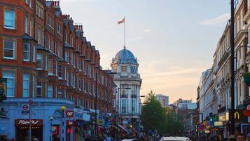 A street with historic buildings, a prominent dome structure, and various commercial establishments.