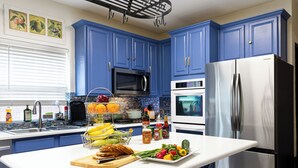 A kitchen with blue cabinets, a stainless steel refrigerator, a microwave, and an oven. - Newly renovated 3 bedroom house near Allen premium outlets (Allen)