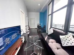 Een moderne woonkamer met een bank, salontafel en een groot raam.