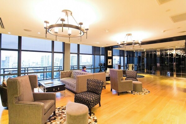 A spacious lobby with a high ceiling, large windows, and modern furniture. - Ultra Luxury 66F Penthouse Skyline View (Makati)
