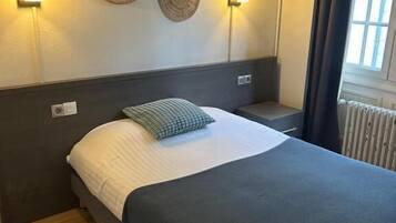 Una habitación de hotel con una cama, dos lámparas de pared y decoración en la pared.