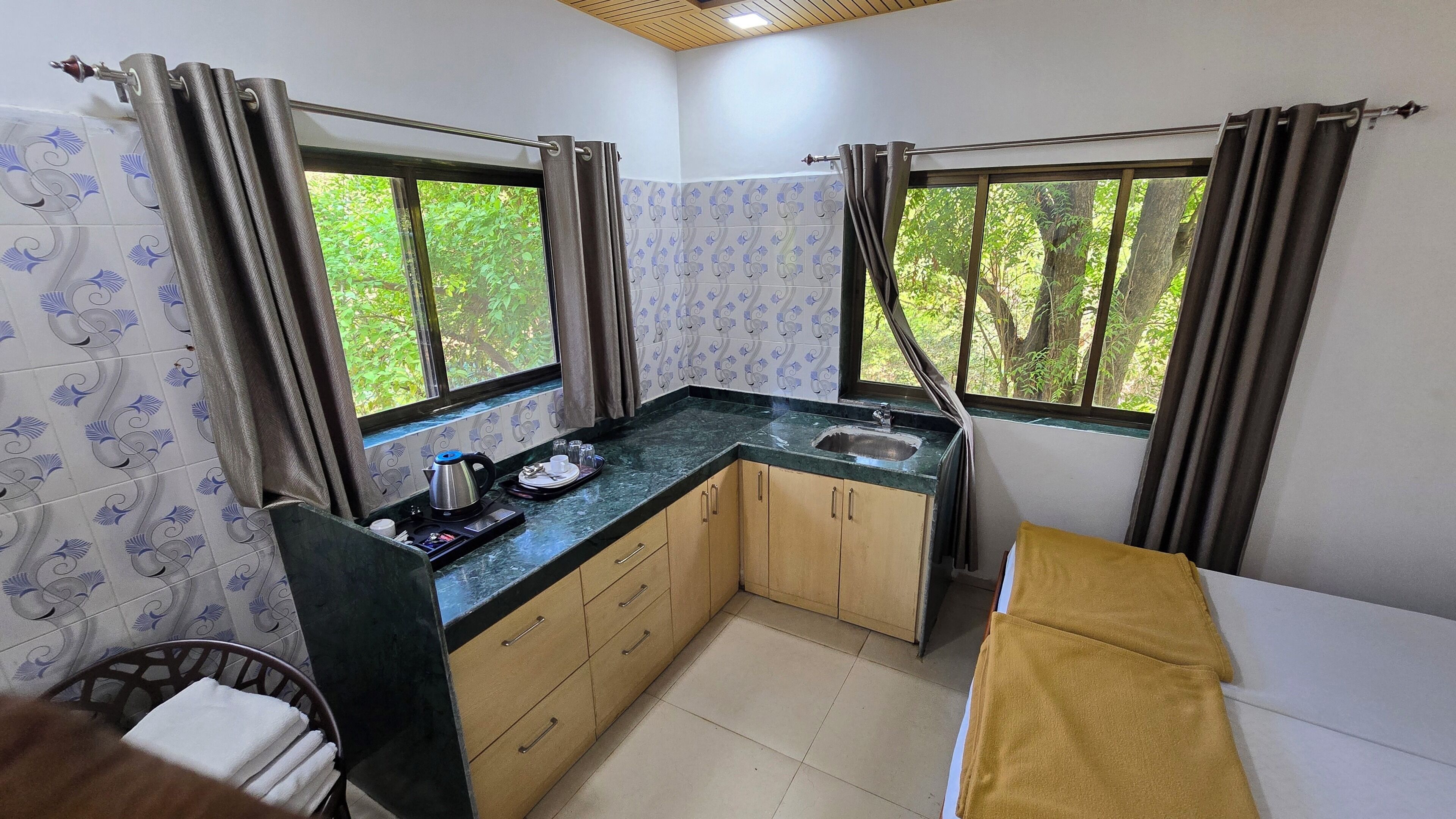 A compact kitchen with two windows, a sink, and a countertop.