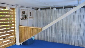 A room with a wooden slatted partition, a blue carpet, a white ceiling, and a bamboo barrier. - Coastal Retreat - 3 min walk to the beach 
Open for Monthly stays (Whangaparāoa)