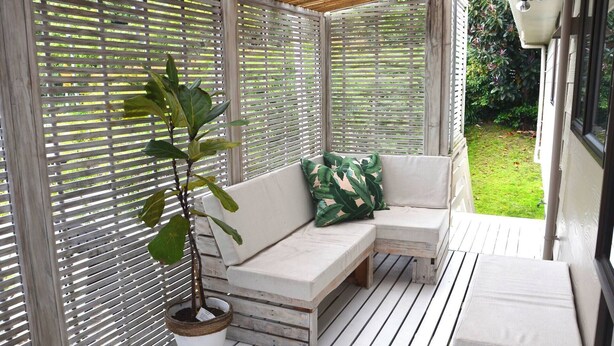 A covered outdoor seating area with a wooden bench and a potted plant. - Coastal Retreat - 3 min walk to the beach 
Open for Monthly stays (Whangaparāoa)