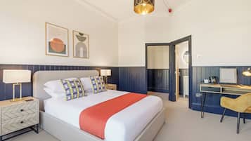 Una habitación de hotel con una cama, mesitas de noche, un escritorio y una silla.