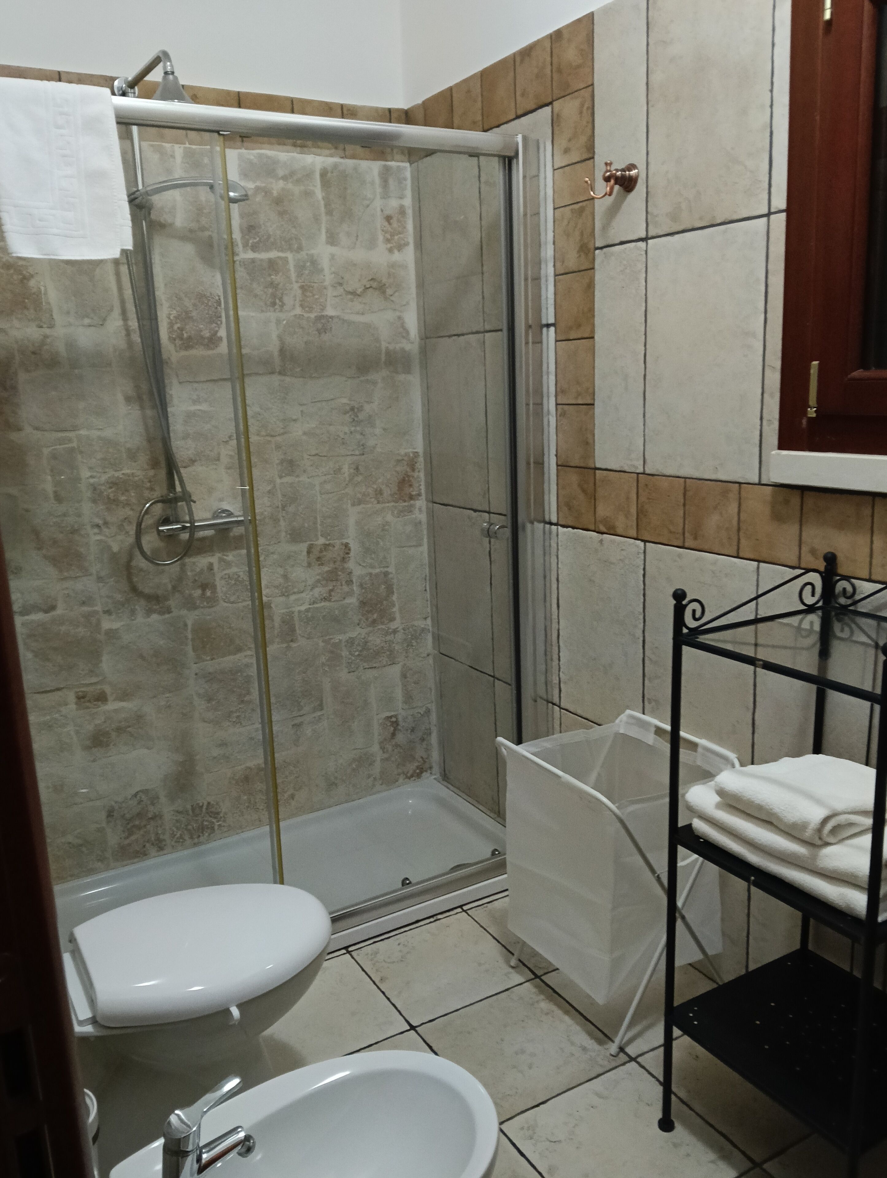 A bathroom with a shower, toilet, and sink.