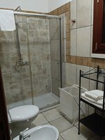 A bathroom with a shower, toilet, and sink.