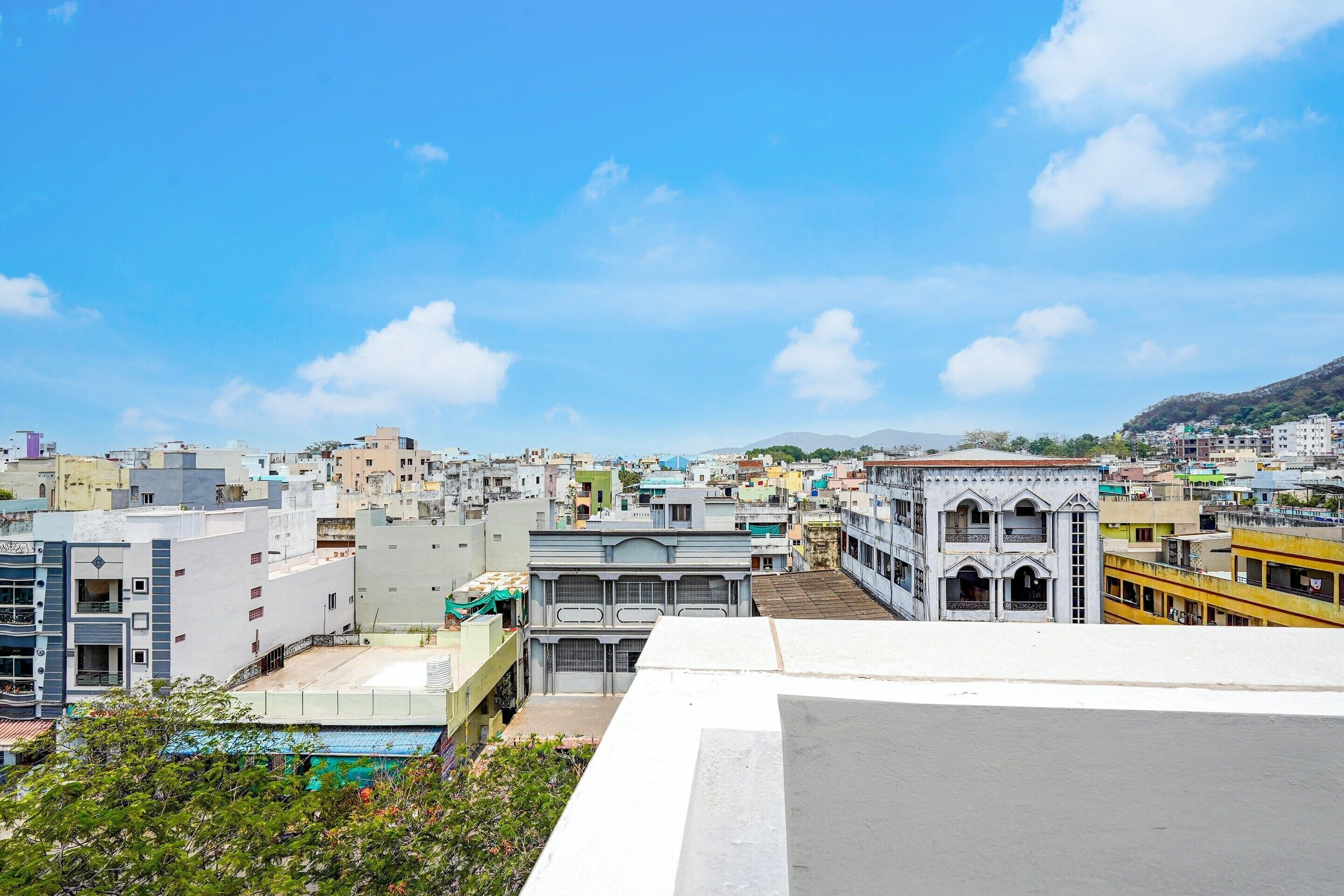A cityscape with various buildings, including a prominent white building with a balcony.