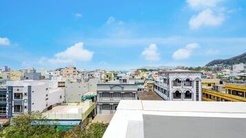 A cityscape with various buildings, including a prominent white building with a balcony.