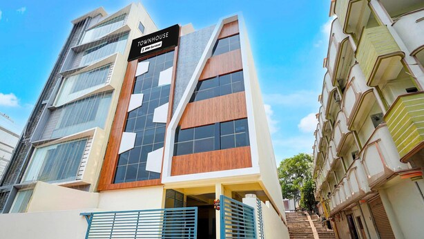 A modern building with a sign reading 'TOUMHOUSE' and 'OTPS-Serviced'.