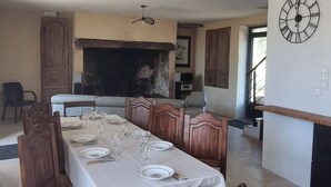 A dining area with a long table set for six, surrounded by wooden chairs. - House with spa in the heart of the countryside (Anglars-Nozac)
