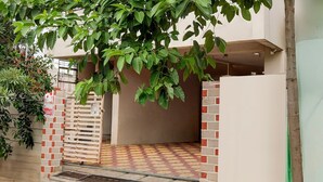 A gated entrance with a tiled floor leading to a covered area.
