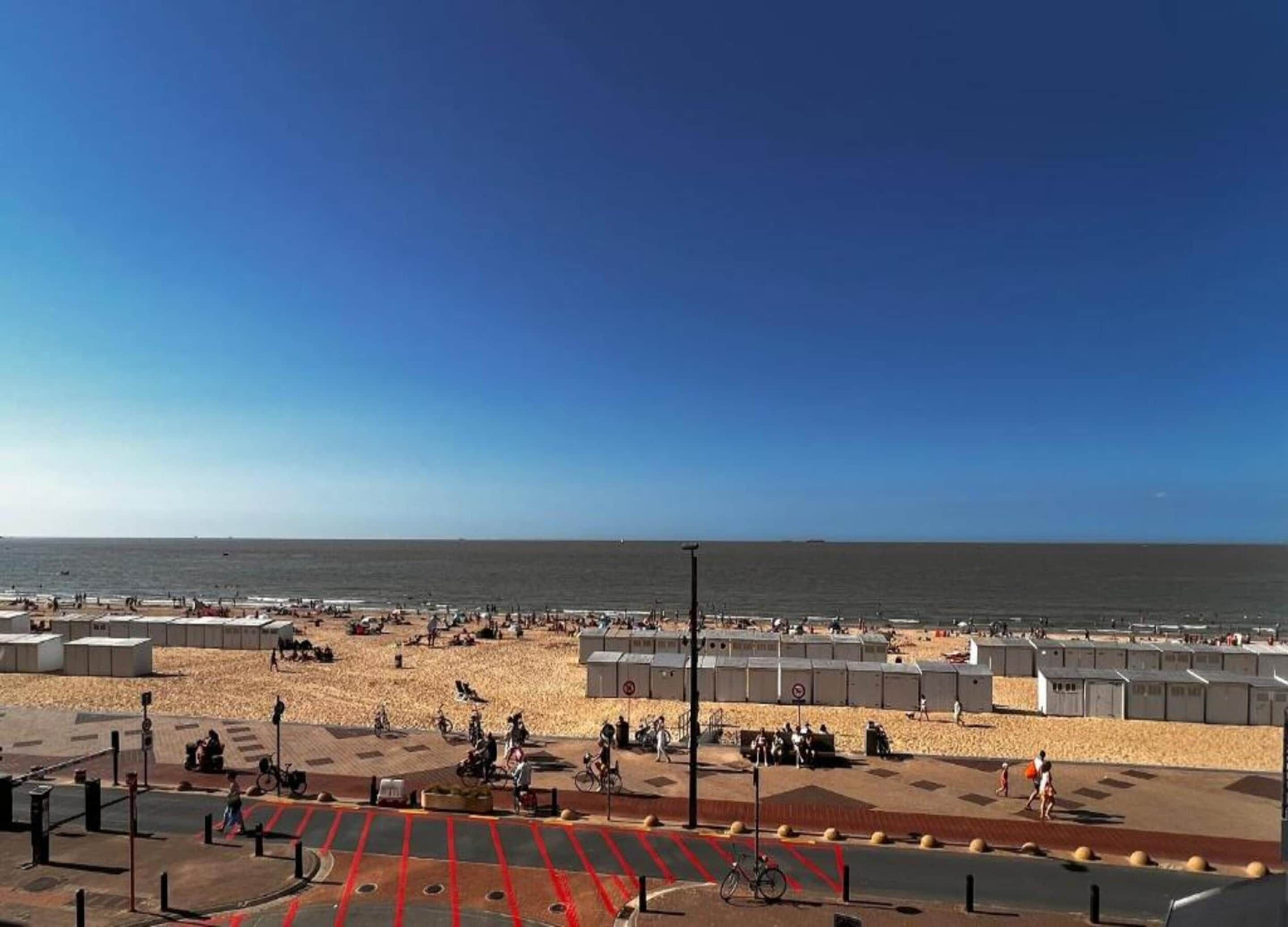 Une plage avec des bâtiments modulaires, un ciel dégagé et une vue sur la mer.