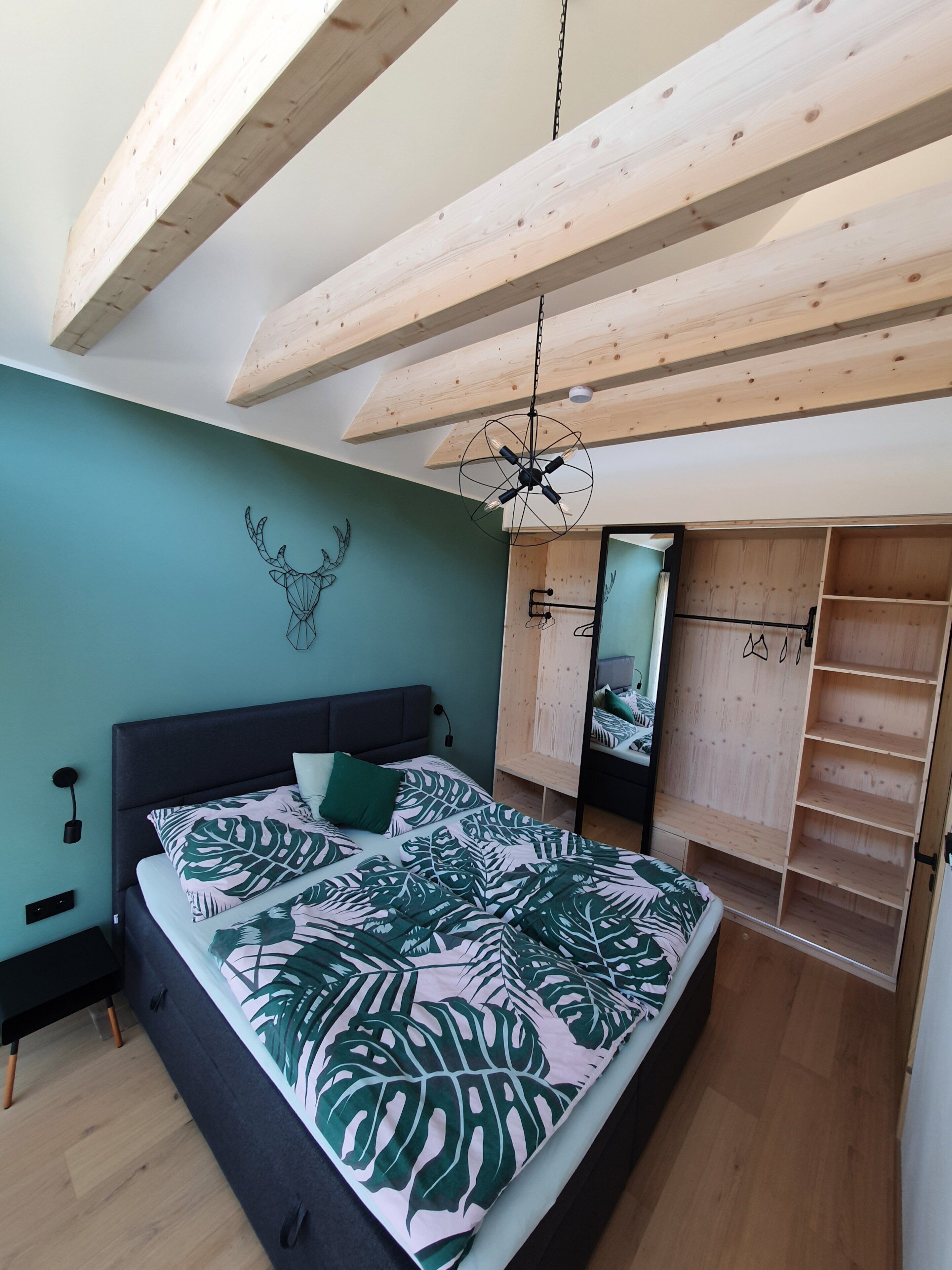 Een slaapkamer met een bed, een kledingkast en een plafondventilator.