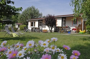 A house with a lawn, a bicycle, and a chair. - Seepark Heidenholz, Plau am See (Plau am See)