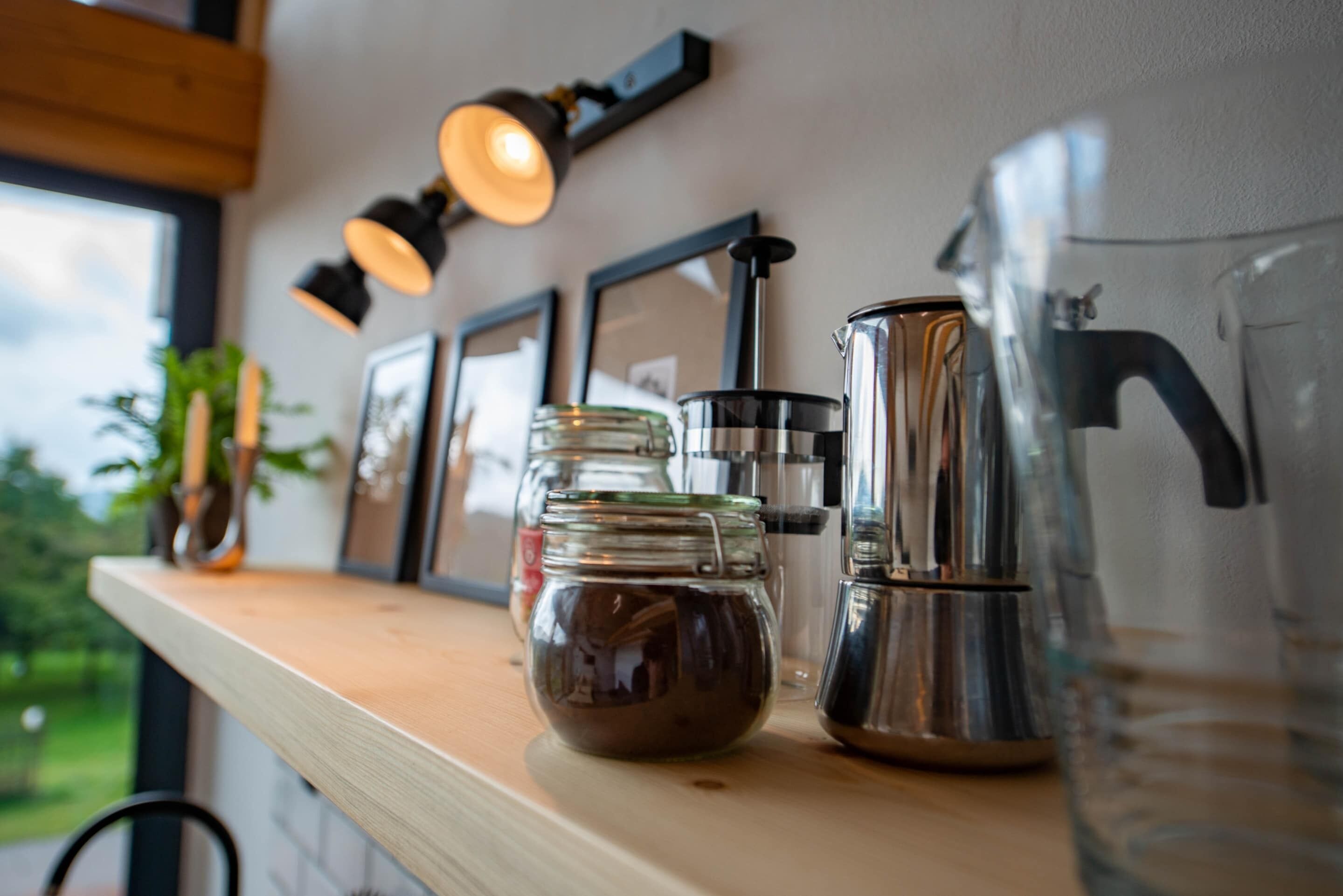 Un comptoir de cuisine avec une machine à café, un bocal en verre et une carafe.