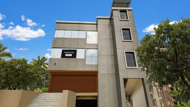 A modern townhouse with a sign indicating 'Townhouse & Company Services.' - Townhouse Near Narsingi Manikonda (Hyderabad)