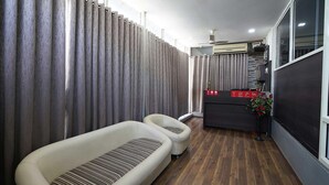 Ein modernes Hotelzimmer mit Holzboden, einer Couch, einem kleinen Tisch und einer Treppe, die in einen oberen Bereich führt.