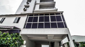 Ein modernes Gebäude mit großem Fenster, Balkon und Eingangstür.