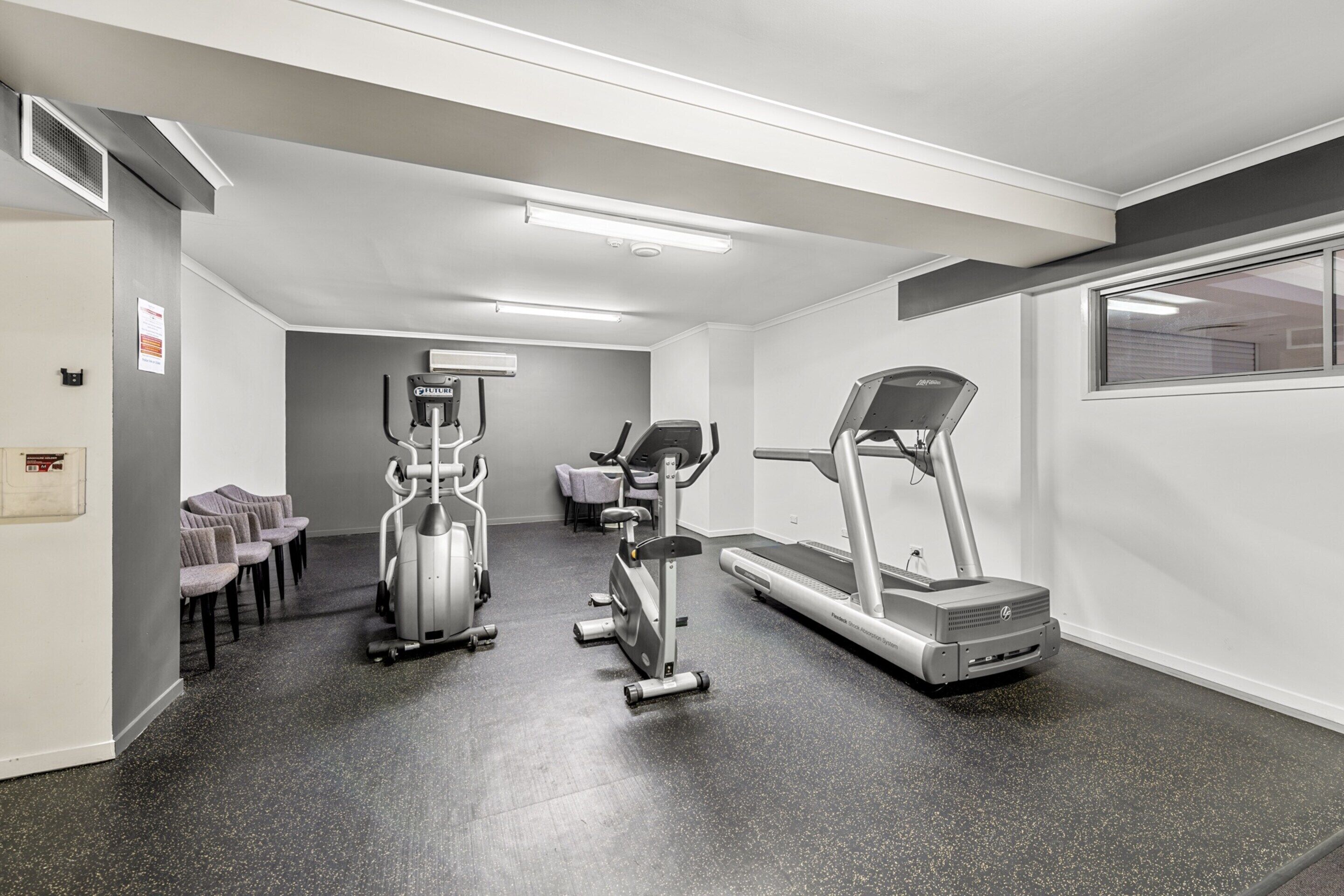 A fitness center with treadmills, elliptical machines, and stationary bikes.