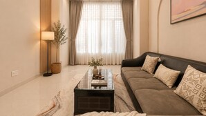 A modern living room with a sofa, a coffee table, and a lamp. - Group Stay in Central Saigon_ 6 Bedrooms + Private Baths (Thành phố Hồ Chí Minh)