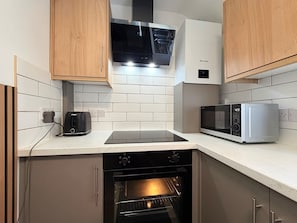 Cozinha equipada com forno embutido, micro-ondas e torradeira.
