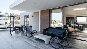 A modern outdoor living area with a sofa, chairs, and a dining table. - Jan Sofat LUX 2BR Penthouse Pool + Mountain View (Willemstad)
